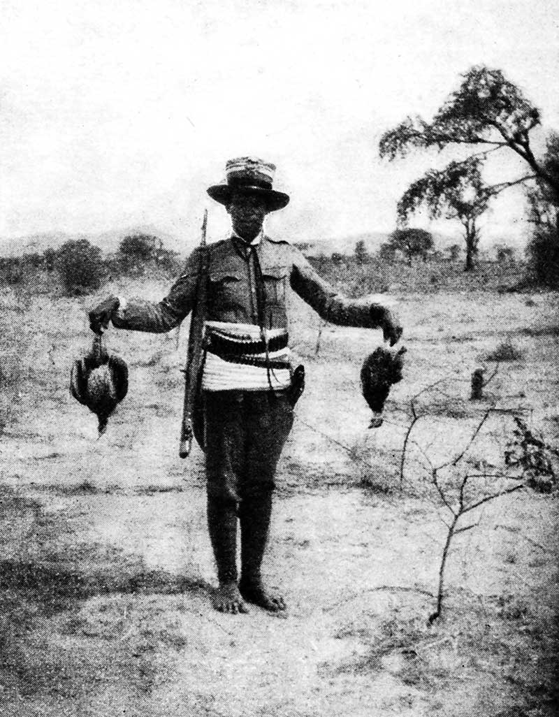 Un aiutante indigeno di Zammarano mostra due uccelli appena uccisi durante una battuta di caccia