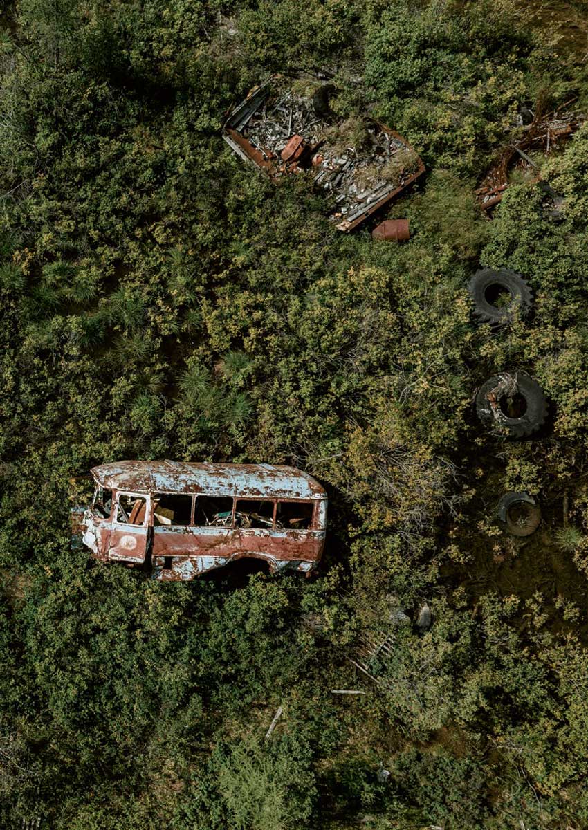 Autobus abbandonato ricoperto da una vegetazione lussureggiante. Foto di Dmitrii Maksimiuk